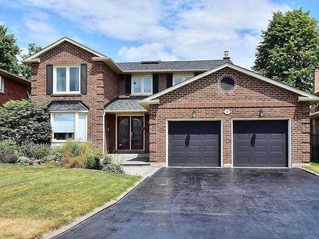 Detached Ajax brick home with two dark garage doors