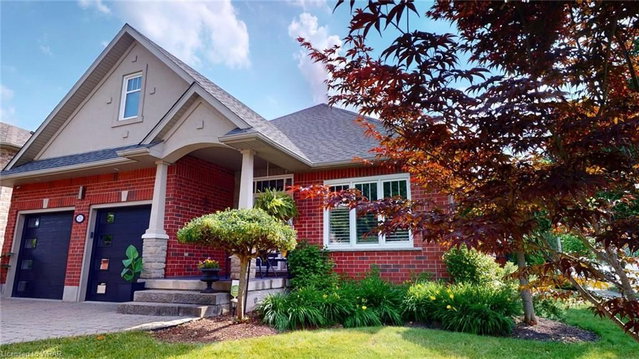 Detached Kitchener home with two dark garage doors