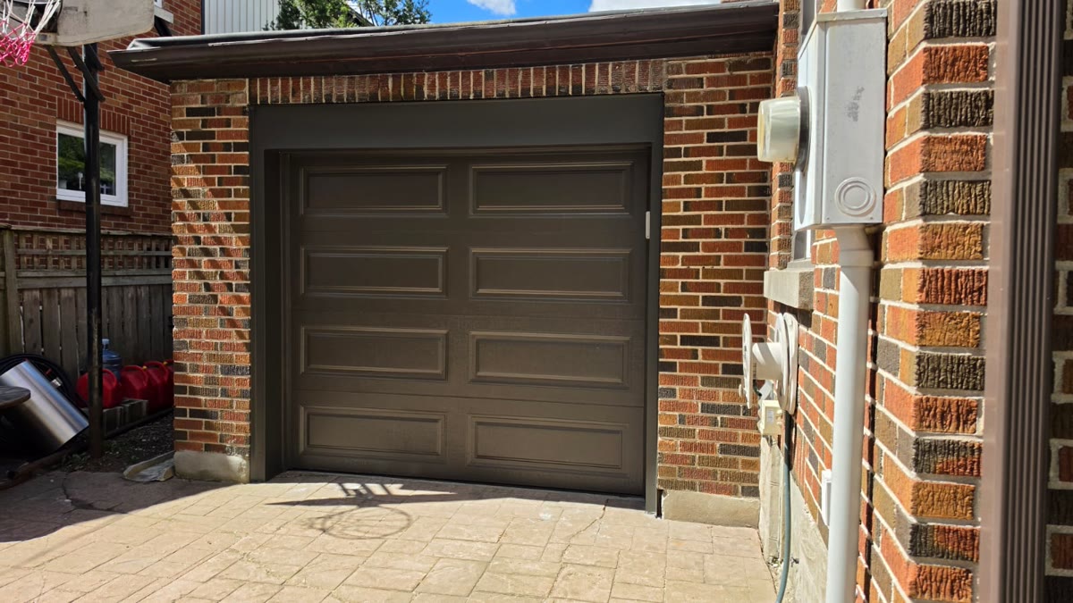 Walnut-toned single garage door with modern panel design