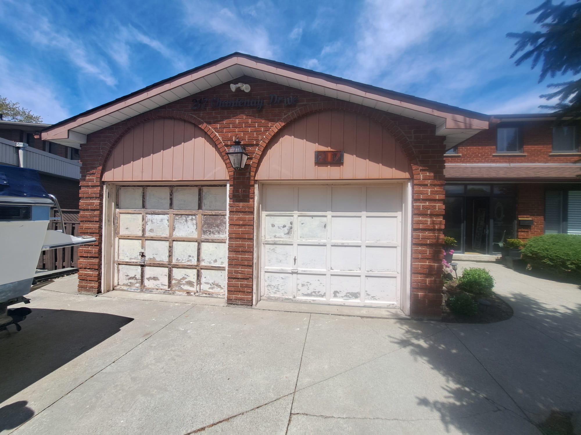 Before RedOak garage door replacement with worn white garage doors