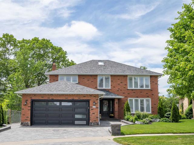 Detached Whitby brick home with a dark garage door