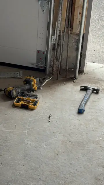 Garage door repair tools arranged beside the door track