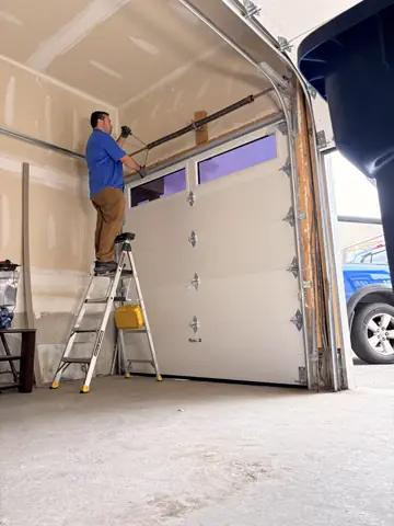 RedOak technician adjusting the garage door spring and lift system